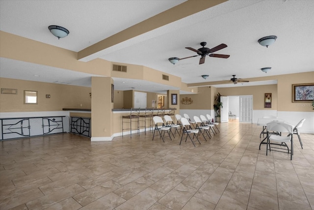 view of patio with ceiling fan and an outdoor bar