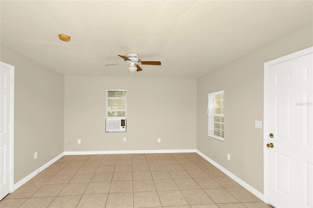 empty room featuring ceiling fan, a textured ceiling, and light tile patterned floors