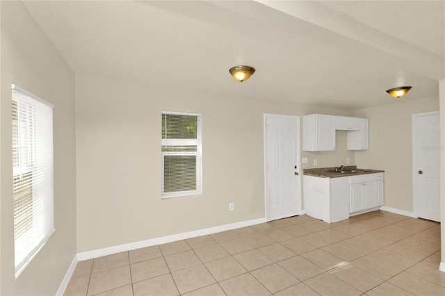 kitchen with white cabinets, light tile patterned flooring, a healthy amount of sunlight, and sink