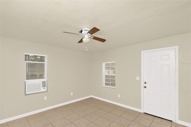 tiled empty room featuring a textured ceiling and ceiling fan