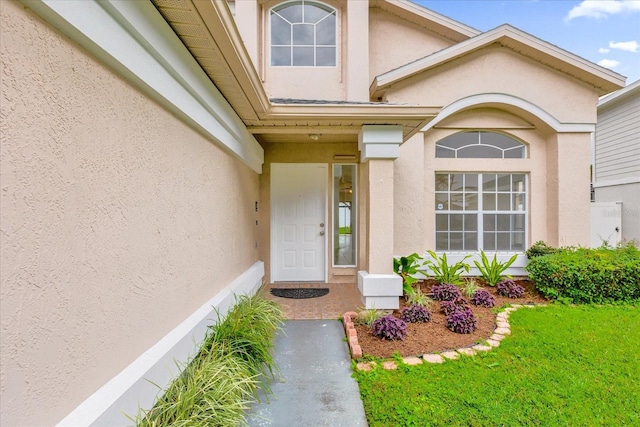 doorway to property featuring a lawn