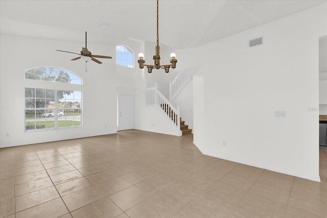 unfurnished living room with high vaulted ceiling, light tile patterned flooring, and ceiling fan with notable chandelier