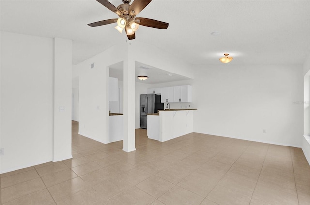 unfurnished living room featuring ceiling fan and light tile patterned floors