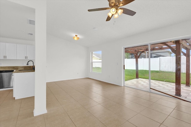 unfurnished living room featuring light tile patterned floors, ceiling fan, and sink