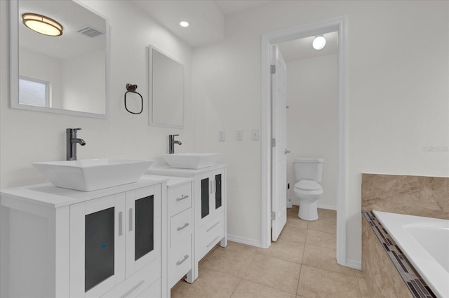 bathroom featuring vanity, tiled bath, tile patterned flooring, and toilet