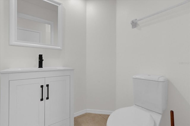 bathroom with toilet, vanity, and tile patterned flooring