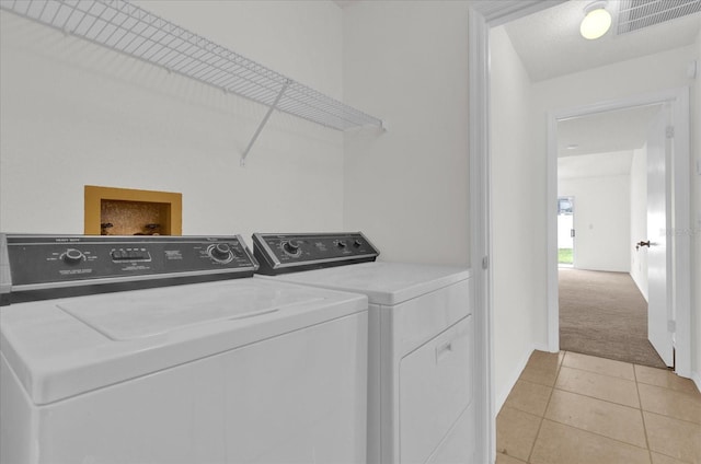 14646 Brightwell Ct, Orlando, FL 32824 - washroom with washer and dryer, light carpet, light tile patterned floors, and baseboards