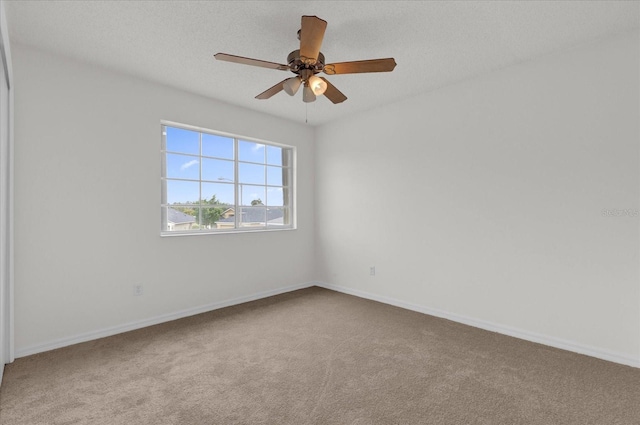 carpeted spare room with ceiling fan and a textured ceiling