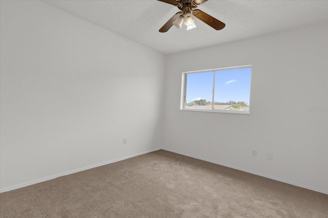 carpeted spare room featuring a textured ceiling and ceiling fan