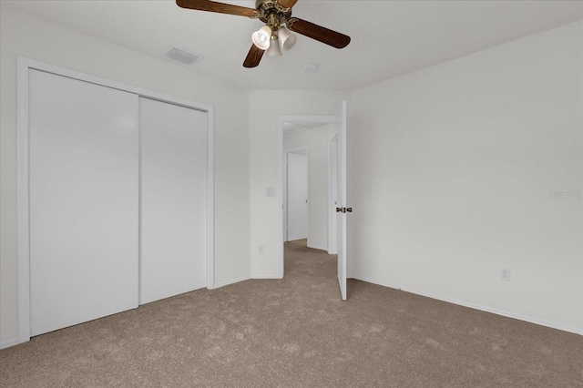 unfurnished bedroom with ceiling fan, a closet, and carpet