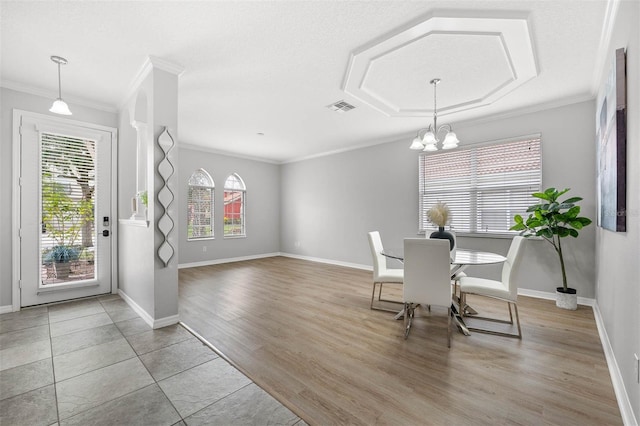 unfurnished dining area with a chandelier, light hardwood / wood-style floors, and crown molding