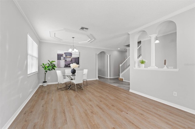 dining space featuring an inviting chandelier, light wood-type flooring, and crown molding