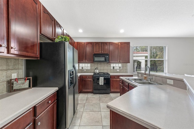 kitchen with sink, black appliances, a textured ceiling, light tile patterned floors, and backsplash