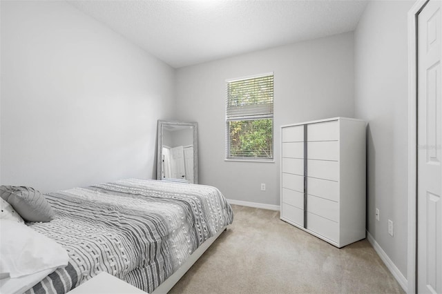 bedroom featuring a textured ceiling and light carpet