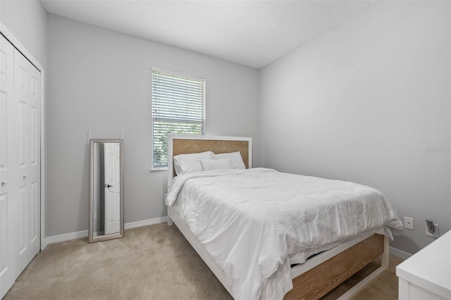 carpeted bedroom with a textured ceiling and a closet