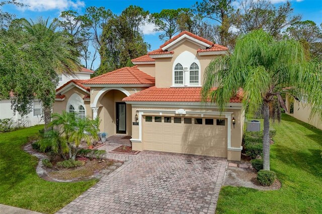 mediterranean / spanish house with a garage and a front lawn