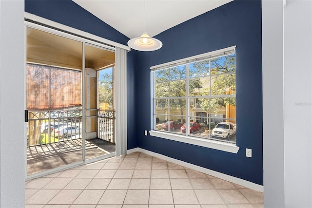 unfurnished dining area featuring tile patterned flooring and lofted ceiling