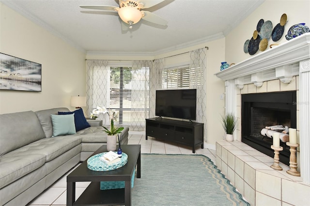 living room featuring a textured ceiling, a tiled fireplace, ornamental molding, and light tile patterned flooring