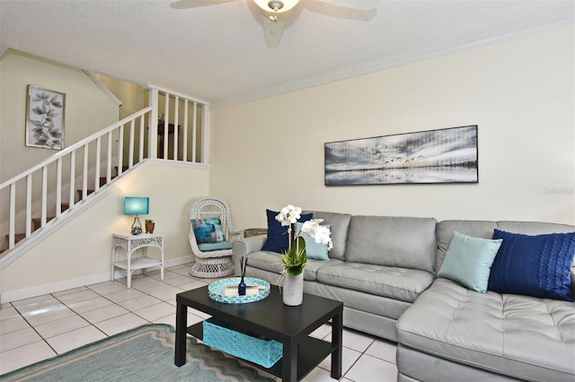 tiled living room featuring ceiling fan, a textured ceiling, and ornamental molding