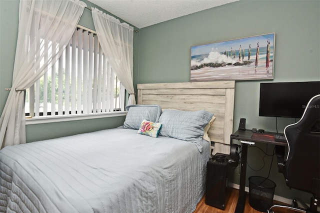 bedroom with hardwood / wood-style flooring and a textured ceiling