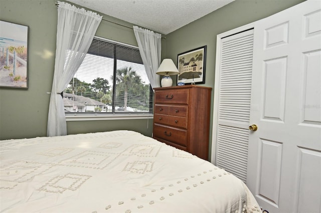 bedroom with a textured ceiling and a closet