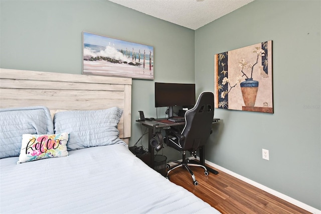 bedroom featuring wood-type flooring and a textured ceiling