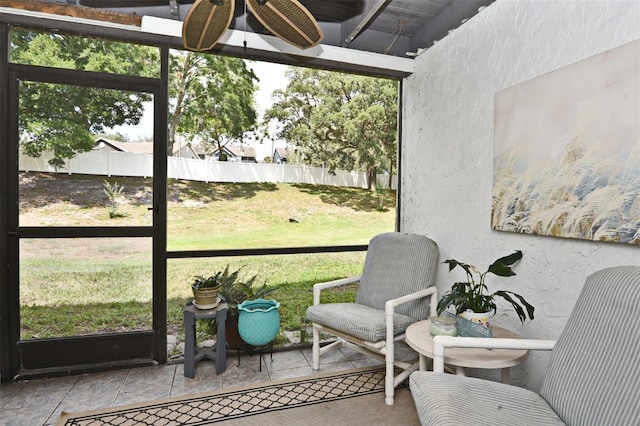 sunroom featuring ceiling fan and plenty of natural light