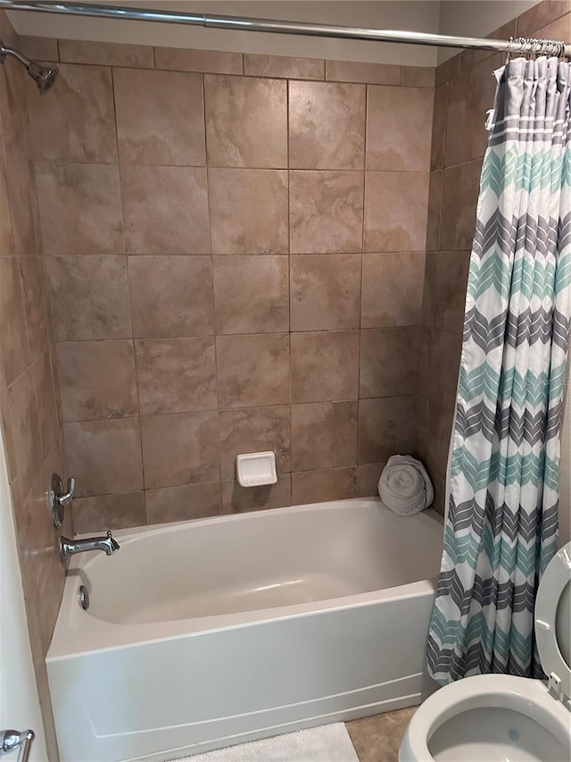 bathroom featuring toilet, tile patterned floors, and shower / tub combo with curtain