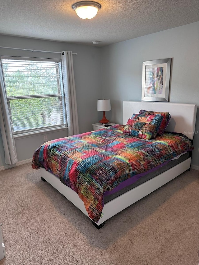 bedroom with carpet and a textured ceiling