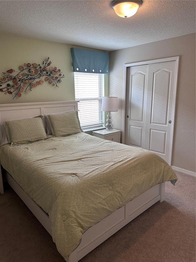 bedroom with carpet floors, a textured ceiling, and a closet