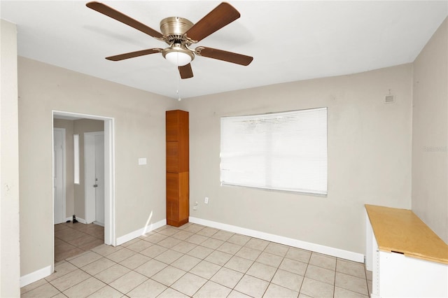 spare room featuring light tile patterned floors and ceiling fan