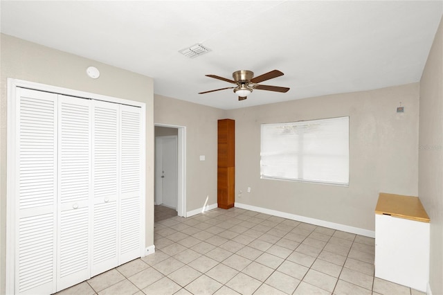 unfurnished bedroom featuring a closet, light tile patterned flooring, and ceiling fan