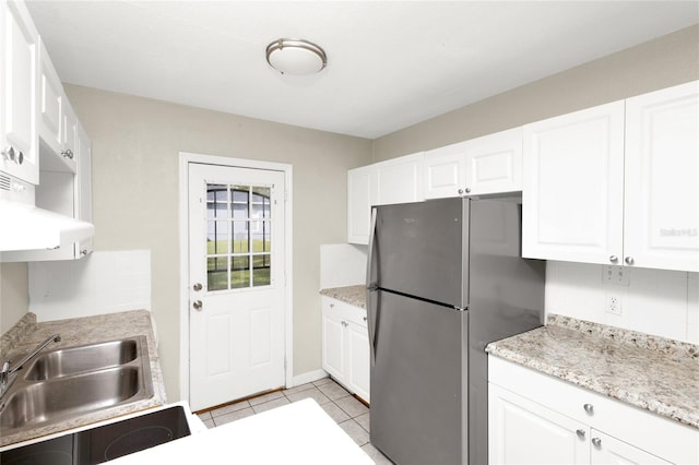 kitchen featuring white cabinets, ventilation hood, stainless steel refrigerator, and light tile patterned flooring