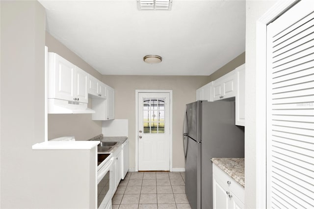 kitchen with white cabinetry, white appliances, and light tile patterned floors