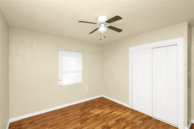 unfurnished bedroom with hardwood / wood-style flooring, ceiling fan, and a closet