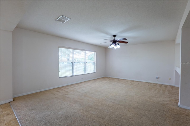 carpeted empty room featuring a textured ceiling and ceiling fan