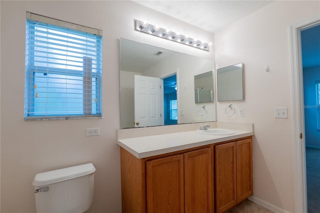 bathroom featuring toilet, vanity, and a textured ceiling