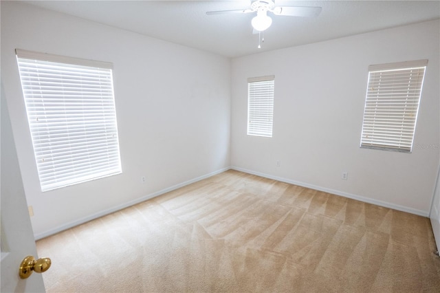 spare room featuring light colored carpet and ceiling fan