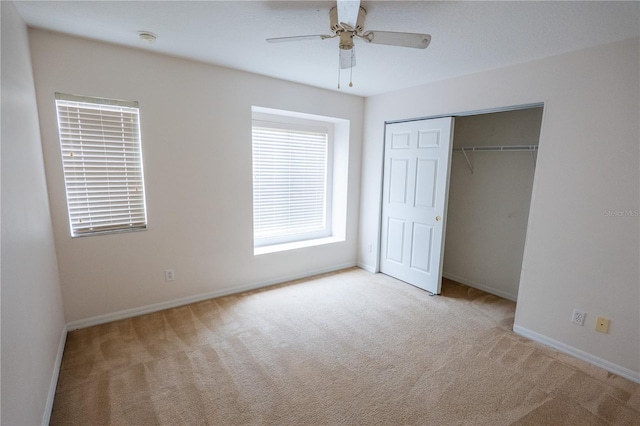 unfurnished bedroom featuring ceiling fan, a closet, and light colored carpet