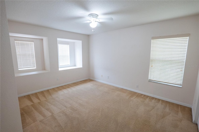 carpeted spare room with ceiling fan and a textured ceiling