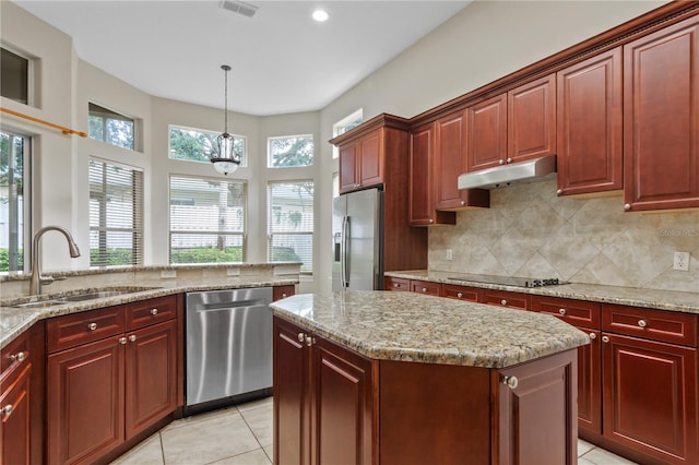 kitchen featuring a kitchen island, appliances with stainless steel finishes, light tile patterned floors, hanging light fixtures, and sink