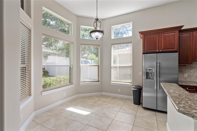 kitchen with decorative backsplash, a healthy amount of sunlight, decorative light fixtures, and stainless steel fridge with ice dispenser