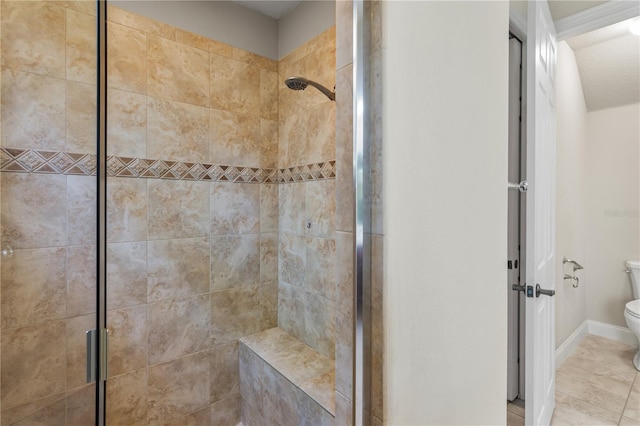 bathroom with tile patterned flooring, toilet, and a shower with shower door