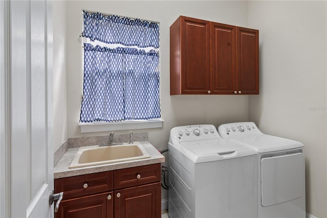 clothes washing area with cabinets, washing machine and dryer, and sink