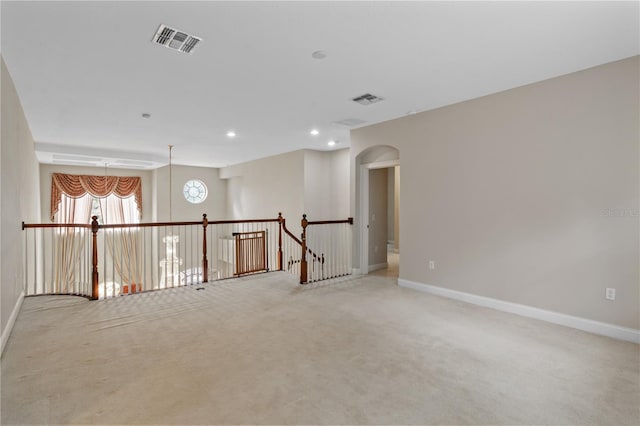 carpeted spare room featuring a chandelier