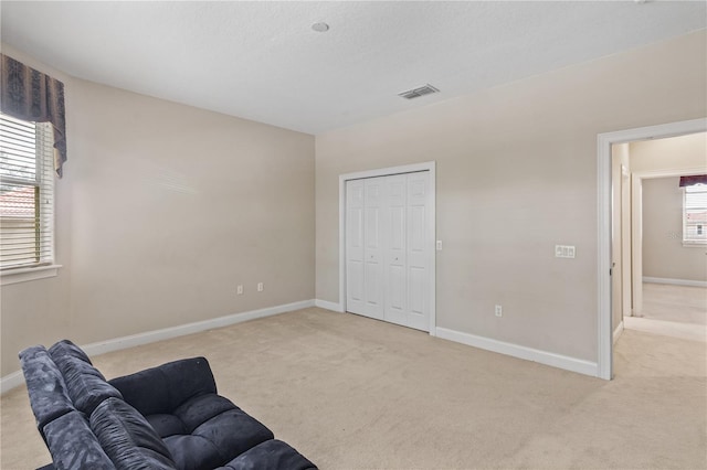 sitting room featuring light carpet and a healthy amount of sunlight