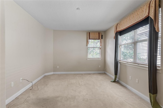 carpeted spare room with a textured ceiling