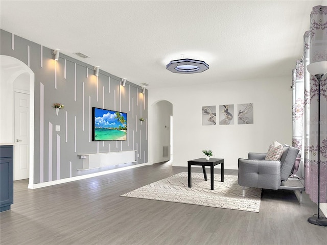 sitting room with a textured ceiling and dark hardwood / wood-style flooring