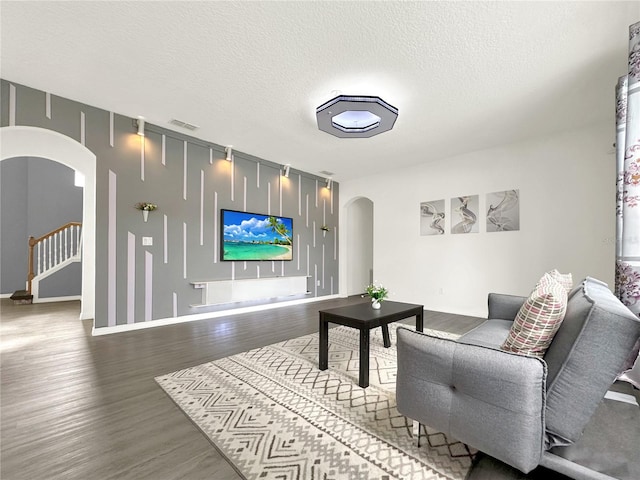 living room featuring wood-type flooring and a textured ceiling