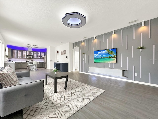 living room featuring hardwood / wood-style flooring, rail lighting, and a textured ceiling